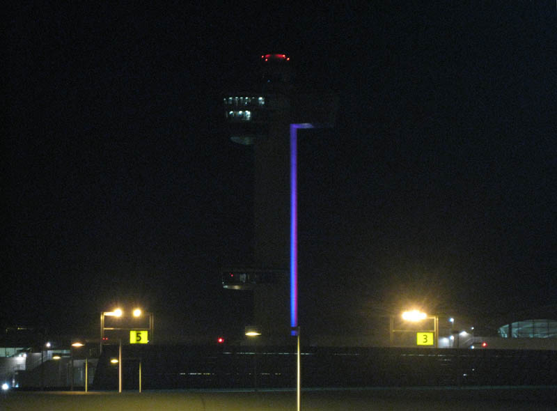 The JFK control tower changes colors at night