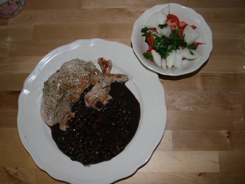 Pork chop, black beans, and colorful salad