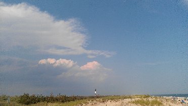 A lighthouse on the horizon and dramatic clouds coming closer. (July 2012) A lighthouse on the horizon and dramatic clouds coming closer. (July 2012)