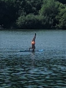 A guy performing headstand on the paddleboard