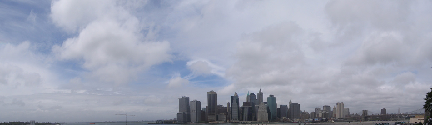 A view from Brooklyn to Lower Manhattan. Leftmost, in the distance, is the Statue of Liberty barely visible. At right, behind the Brooklyn Bridge, in the distance is the Empire State Building (June 2006)